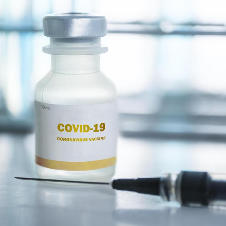 Phiole mit Covid-19-Impfstoff und Injektionsnadel.