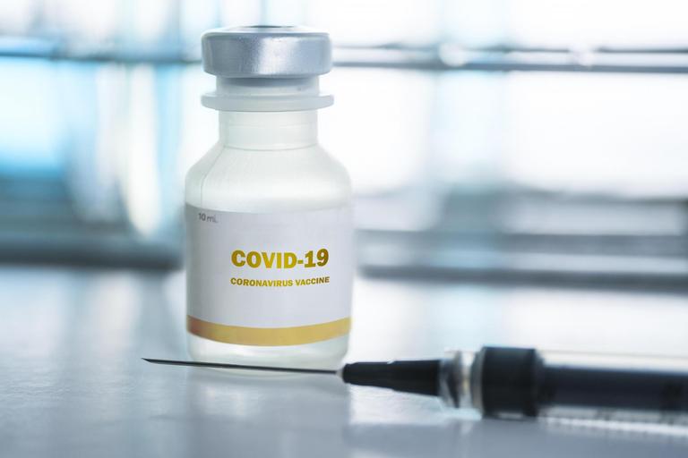 Phiole mit Covid-19-Impfstoff und Injektionsnadel.
