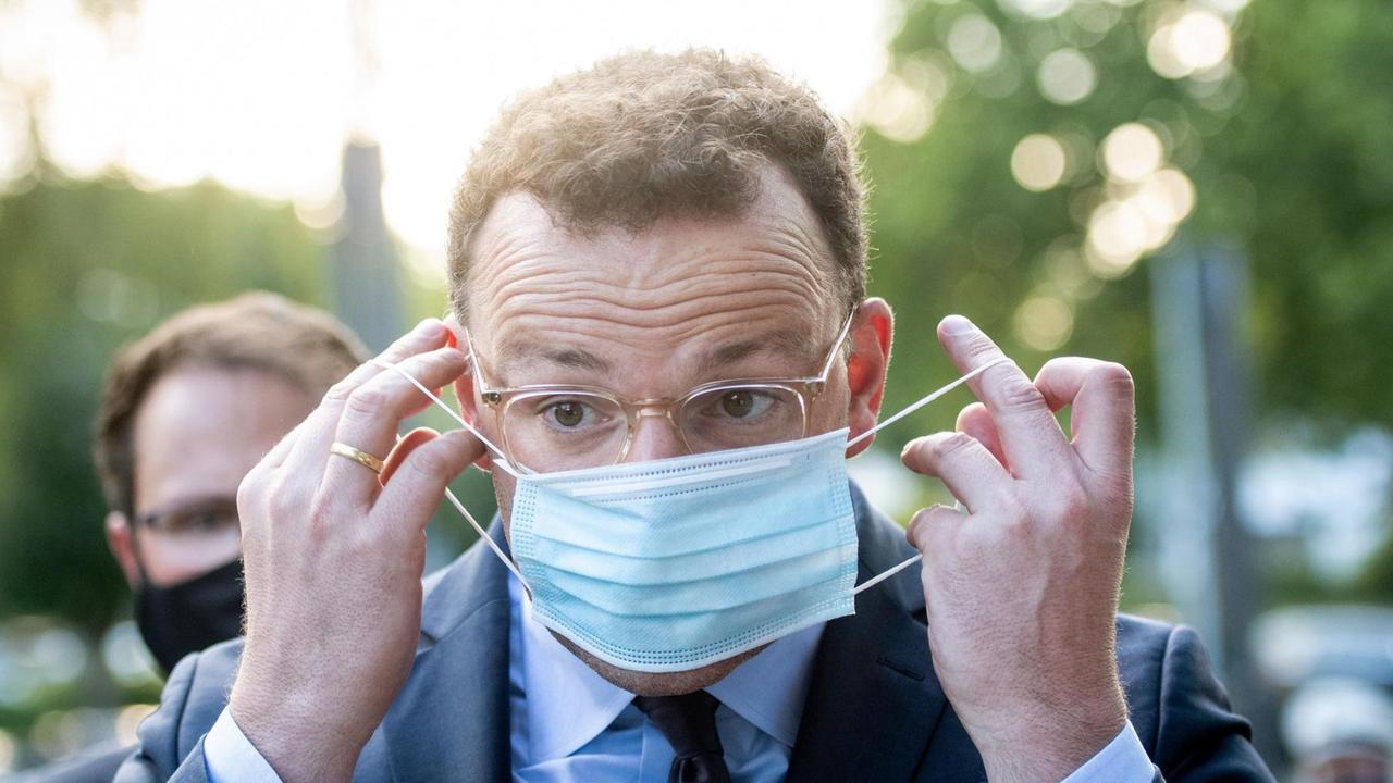 Jens Spahn, Bundesgesundheitsminister (CDU), zieht seine Mund-Nasenschutz-Maske über. 