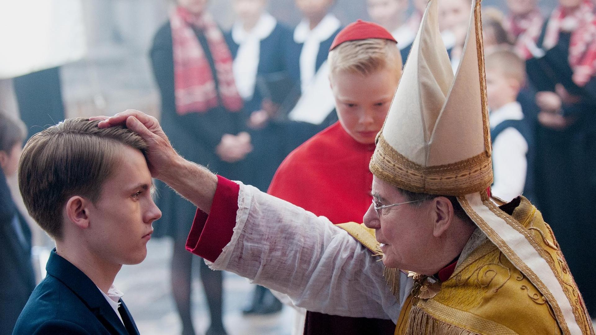 Kardinal Barbarin (François Marthouret) bei der Firmung von Alexandres Sohn Gauthier Guérin (Max Libert)