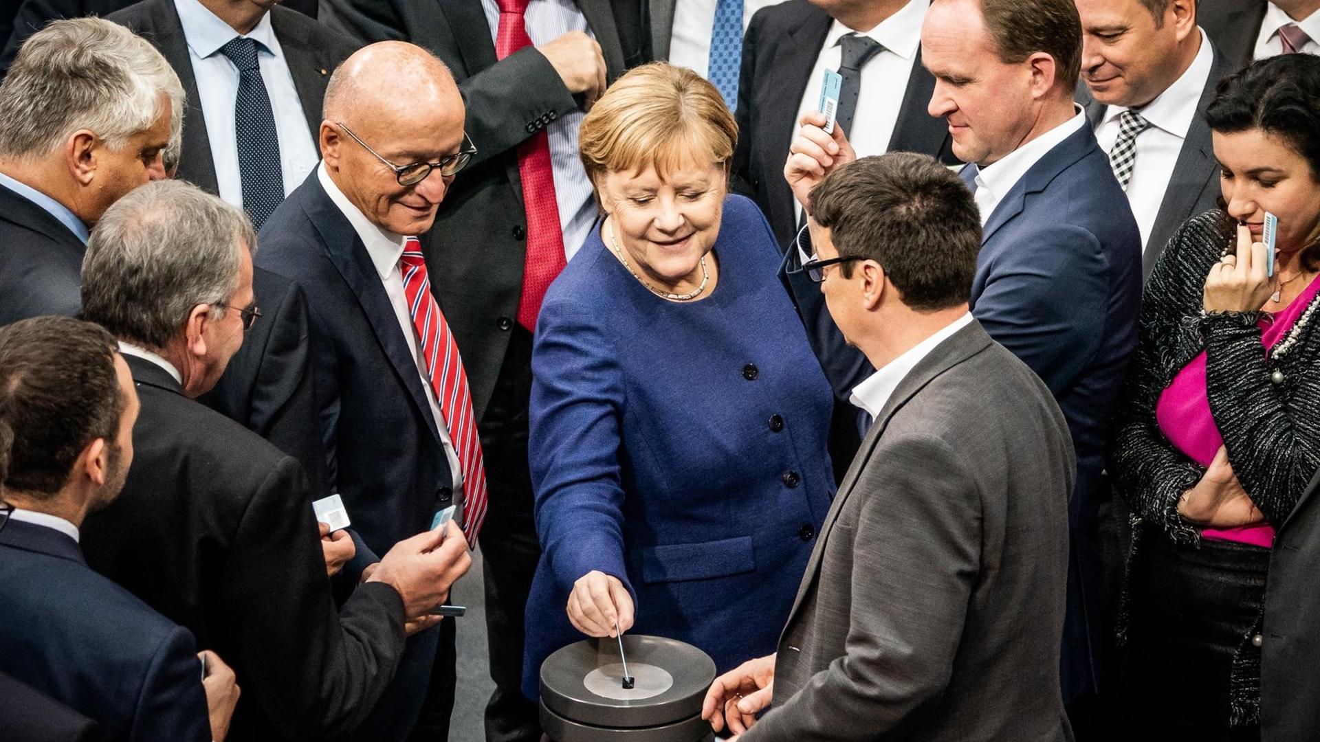 Bundestag: Kanzlerin Angela Merkel (CDU) wirft bei der namentlichen Abstimmung zum Solidaritätszuschlag am 14.11.2019 ihre Stimmkarte ein Bundestag: Kanzlerin Angela Merkel (CDU) wirft bei der namentlichen Abstimmung zum Solidaritätszuschlag am 14.11.2019 ihre Stimmkarte ein