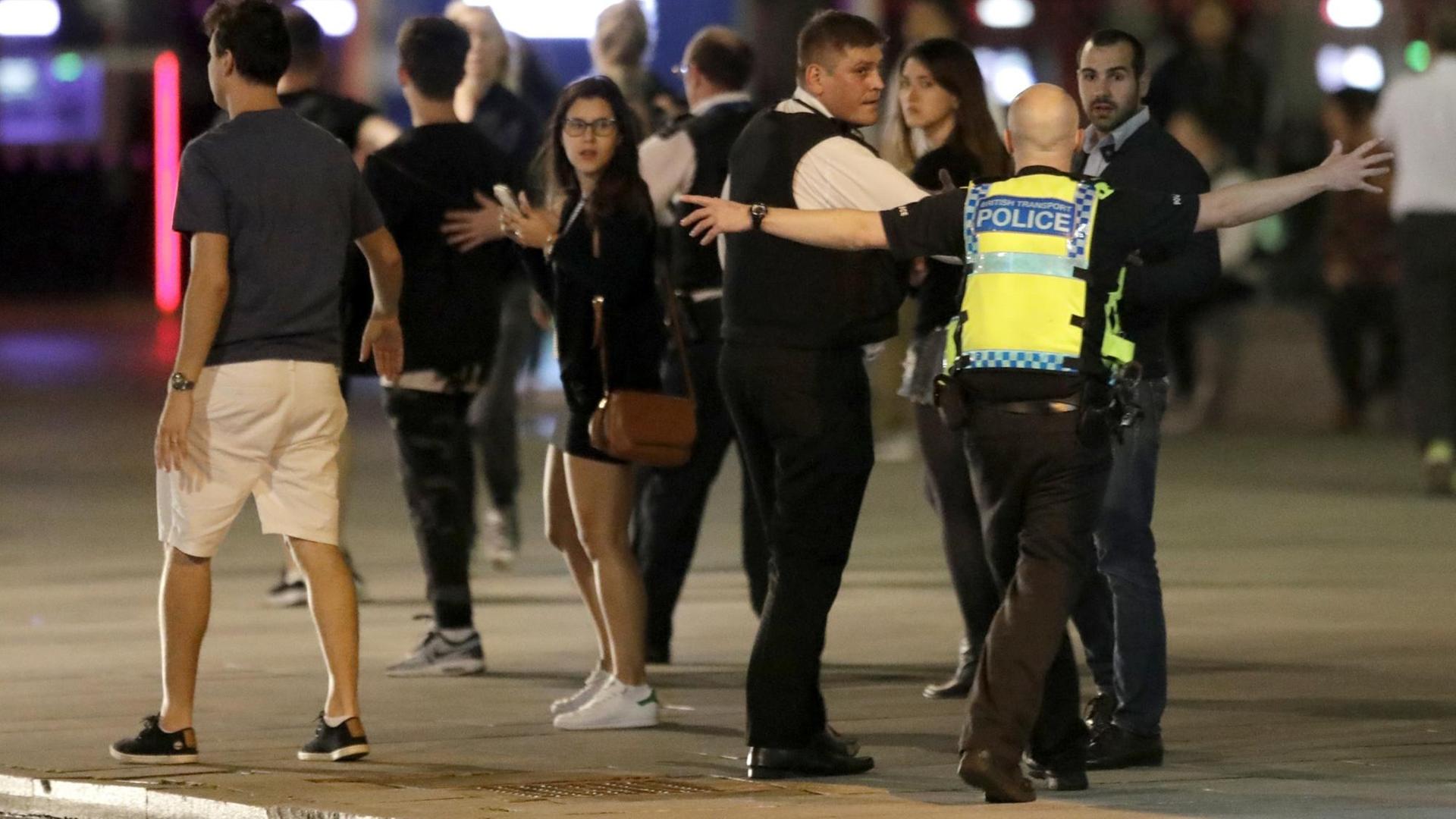 Polizisten versuchen in London, die Menschen vom Ort des Attentats am Samstagabend fernzuhalten. Polizisten versuchen in London, die Menschen vom Ort des Attentats am Samstagabend fernzuhalten.
