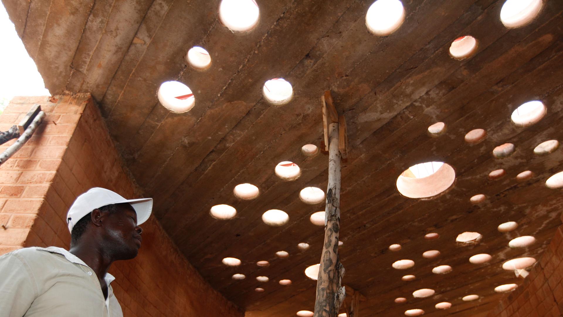 Der Architekt Francis Kéré begutachtet in dem burkinischen Dorf Gando den Baufortschritt an einem Bibliotheksgebäude. Der Architekt Francis Kéré begutachtet in dem burkinischen Dorf Gando den Baufortschritt an einem Bibliotheksgebäude.