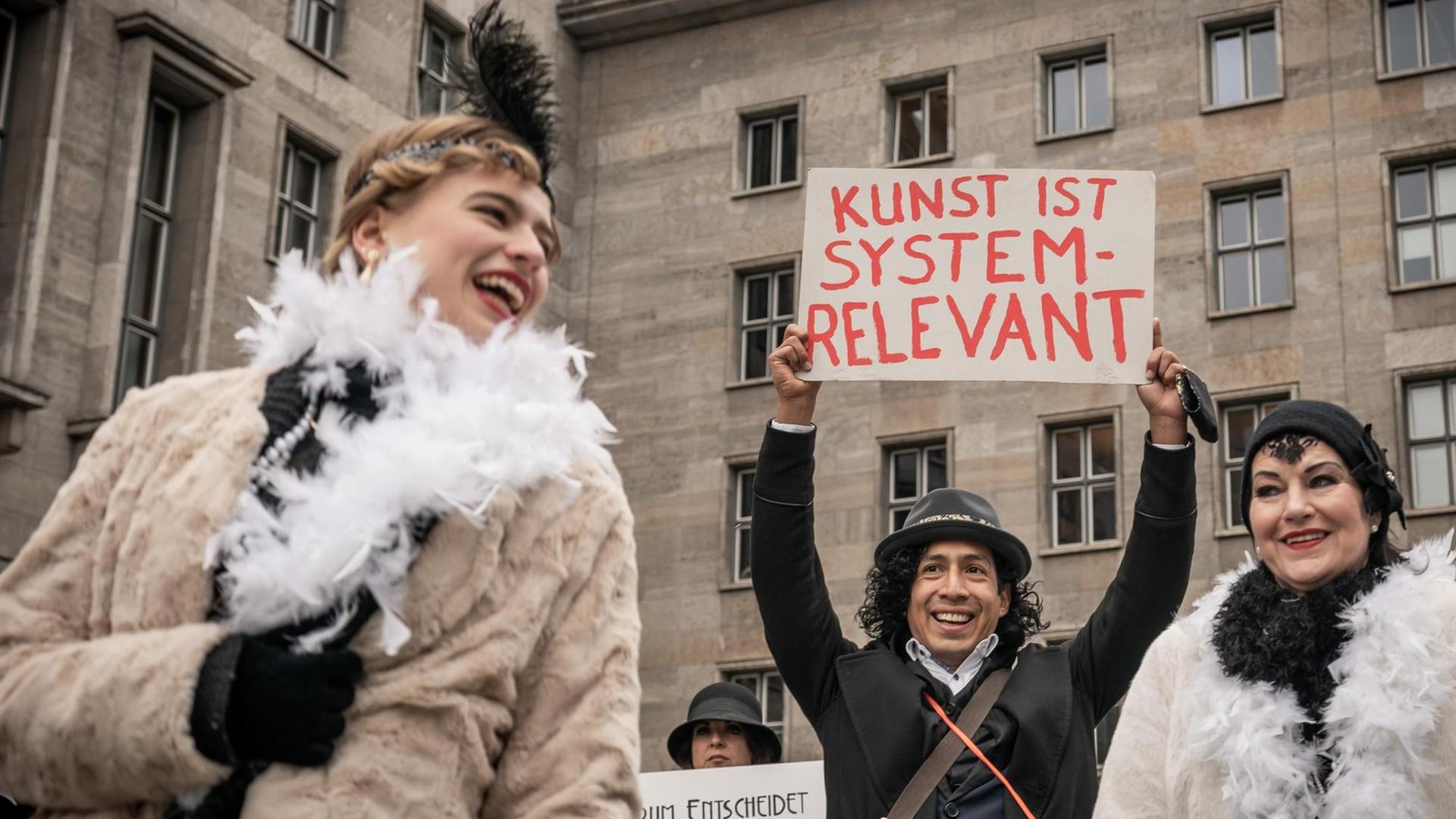 Künstler demonstrieren für wirksame Corona-Hilfen für Soloselbstständige vor dem Finanzministerium mit Schildern, unter anderem mit der Aufschrift „Kunst ist systemrelevant“. Künstler demonstrieren für wirksame Corona-Hilfen für Soloselbstständige vor dem Finanzministerium mit Schildern, unter anderem mit der Aufschrift „Kunst ist systemrelevant“.