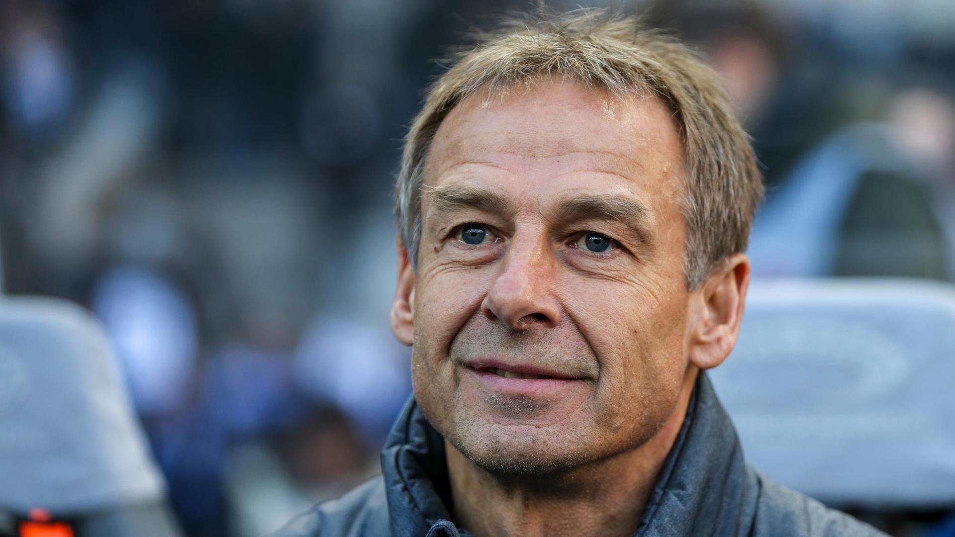 Auf dem Bild ist Jürgen Klinsmann. Er steht nehmen einem Fußball-Feld. Auf dem Bild ist Jürgen Klinsmann. Er steht nehmen einem Fußball-Feld.
