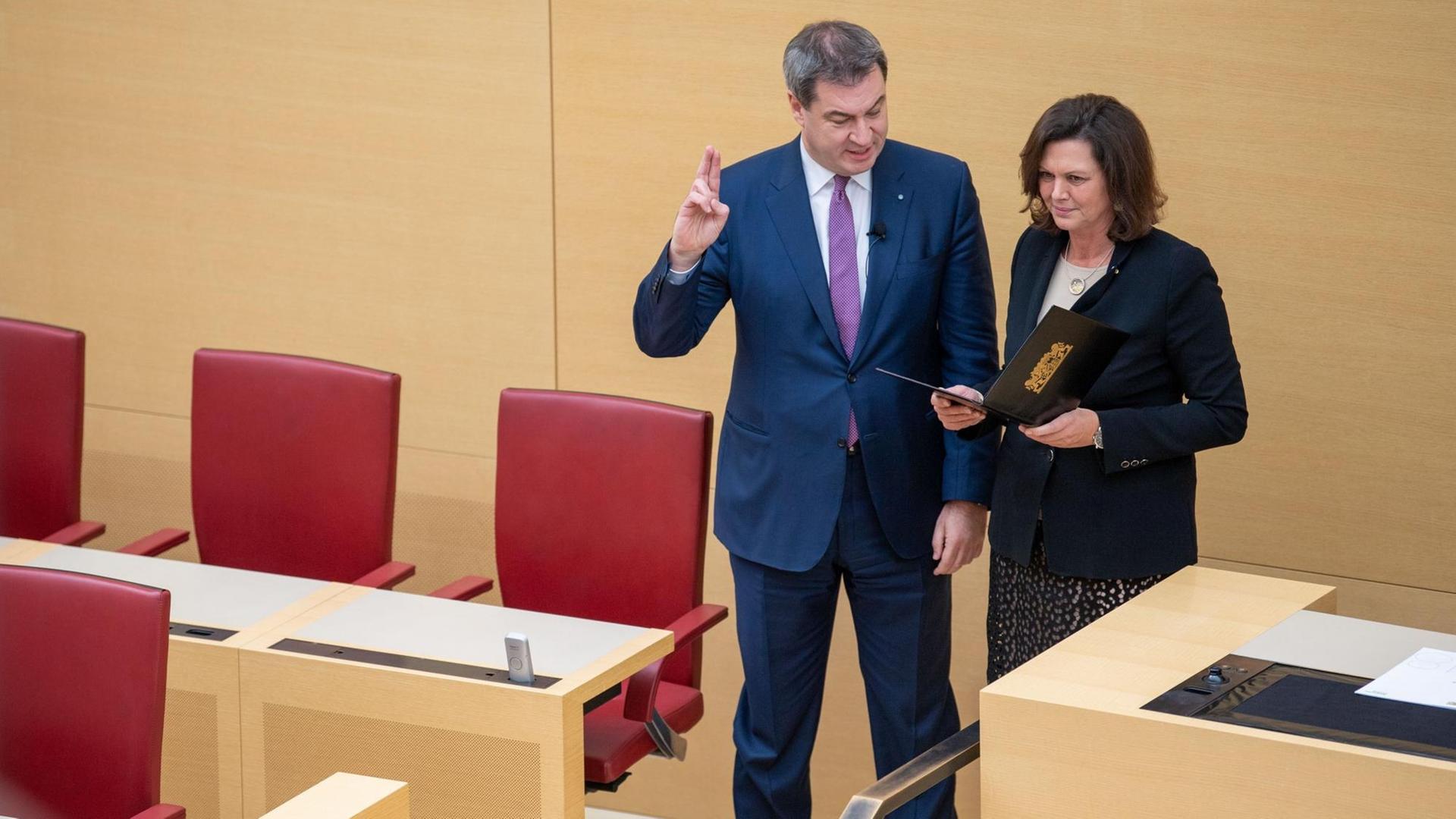 Markus Söder (l,CSU), neu gewählter Ministerpräsident von Bayern, legt während der Sondersitzung des bayerischen Landtags neben Ilse Aigner (CSU), Landtagspräsidentin, den Eid auf die Bayerische Verfassung ab. Markus Söder (l,CSU), neu gewählter Ministerpräsident von Bayern, legt während der Sondersitzung des bayerischen Landtags neben Ilse Aigner (CSU), Landtagspräsidentin, den Eid auf die Bayerische Verfassung ab.