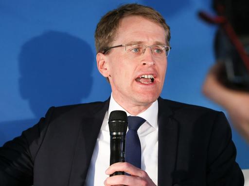 Günther auf der Bühne vor Kameras, mit Mikrofon in der Hand und gestikulierend.