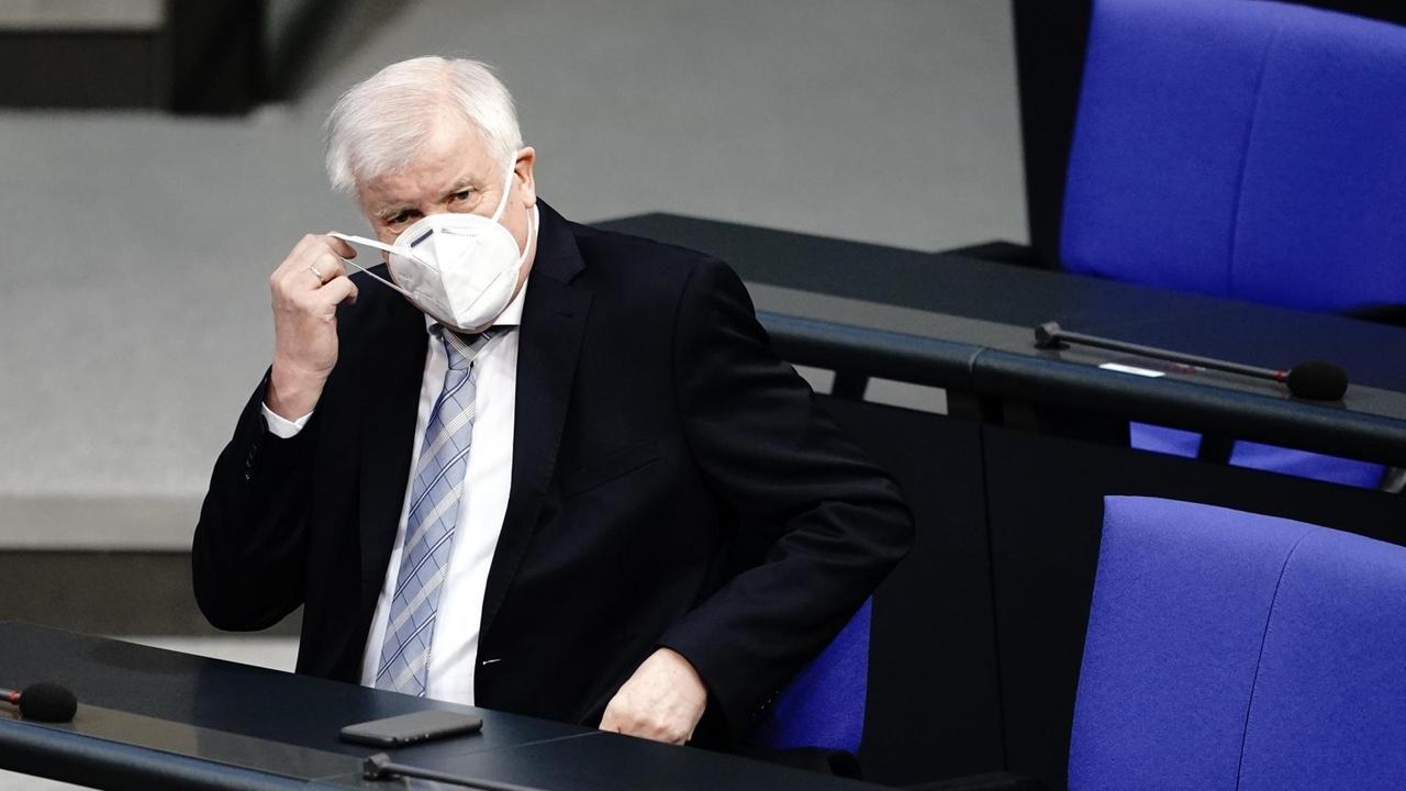 Horst Seehofer (CSU), Bundesminister des Innern, für Bau und Heimat, kommt mit Mund-Nasenbedeckung zur Sitzung des Bundestages. 