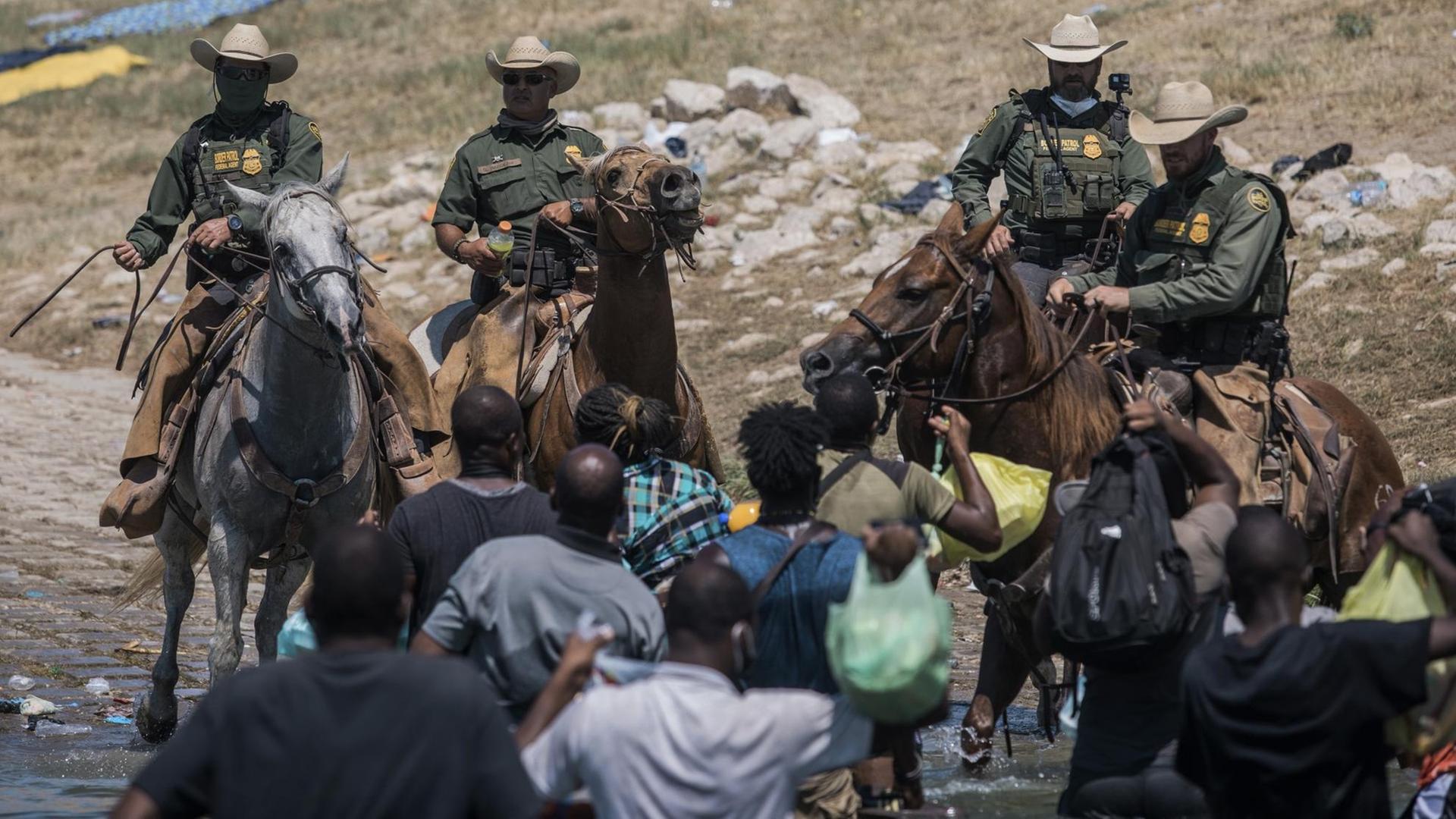 Beamte der US-Zoll- und Grenzschutzbehörde versuchen, Migranten bei der Überquerung des Rio Grande in Texas aufzuhalten. Beamte der US-Zoll- und Grenzschutzbehörde versuchen, Migranten bei der Überquerung des Rio Grande in Texas aufzuhalten.