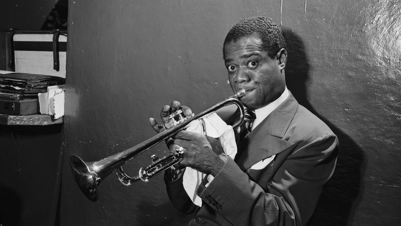 Eine historsiche scharz-weiße Aufnahme von Louis Armstrong mit seiner Trompete im Jazzclub Aquarium in New York City im Juli 1946.