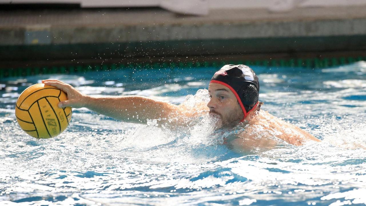 Wasserballer Marko Stamm mit schwarzer Badekappe greift im Wasser nach einem gelben Ball. Wasserballer Marko Stamm mit schwarzer Badekappe greift im Wasser nach einem gelben Ball.