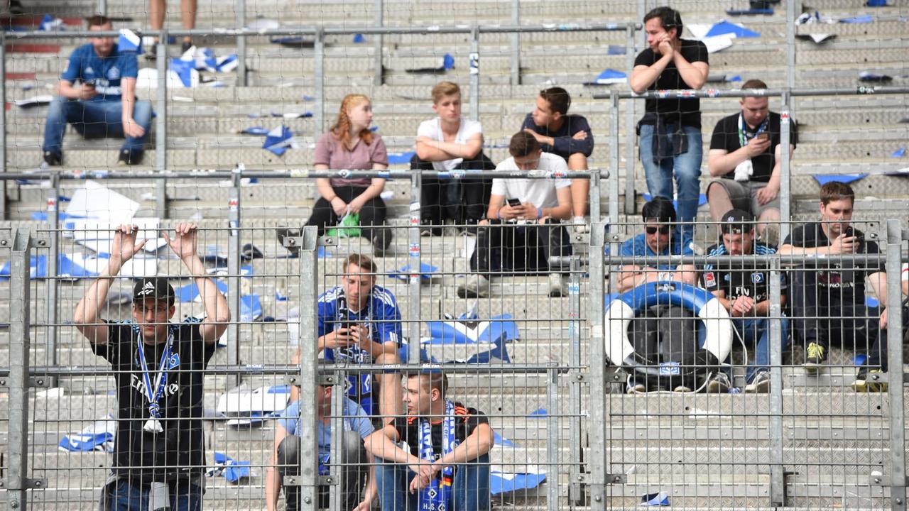 Fans von Hamburg sitzen nach Spielende traurig auf der halbleeren Tribüne. Der Hamburger SV steigt erstmals in seiner Vereinsgeschichte aus der Fußball-Bundesliga ab. 