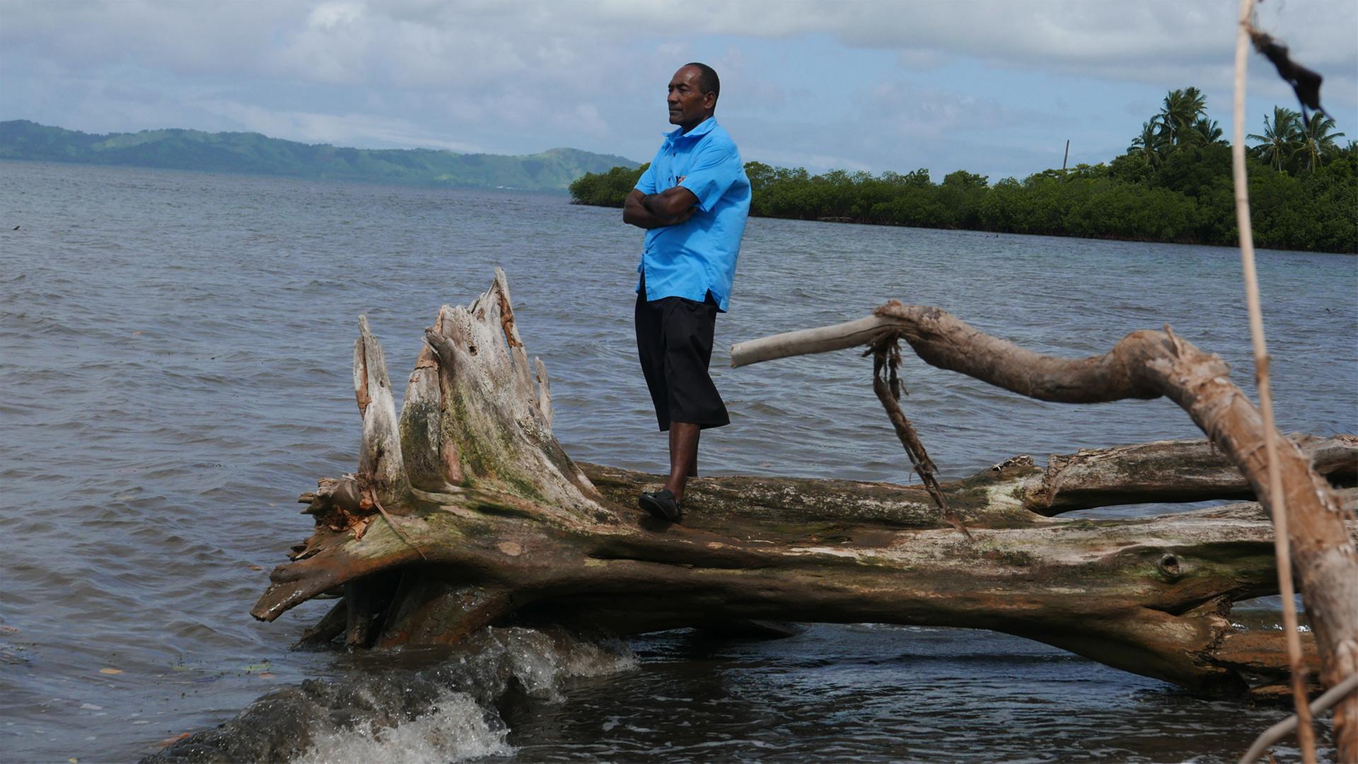 Sailosi Ramatu, Oberhaupt des Dorfs Vunidogoloa auf den Fidschi-Inseln, steht auf einem umgefallenen Baum am Strand.