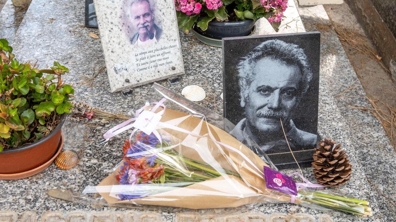 Das Grab von Georges Brassens im französischen Sète mit Fotos des Künstlers und Blumen