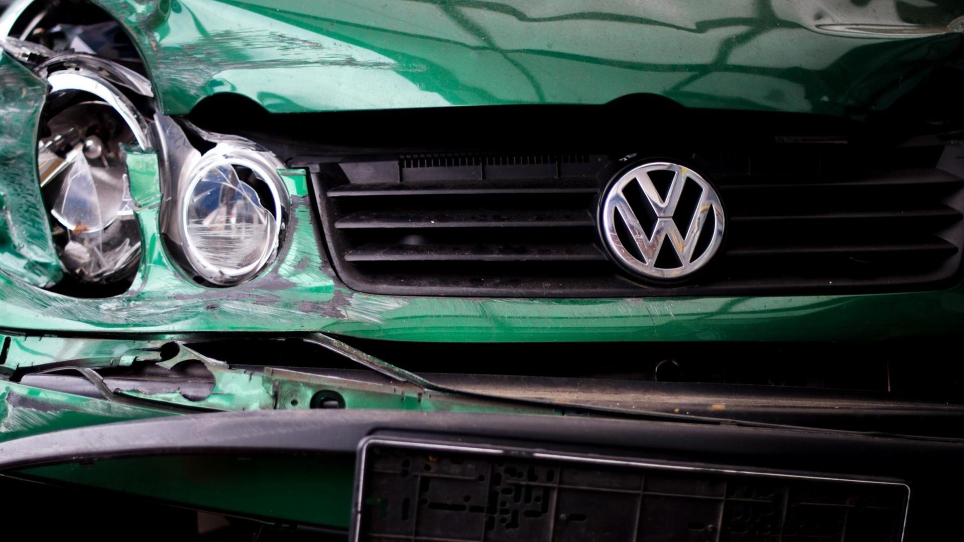 Ein kaputter grüner VW als Symbol für den Abgas-Skandal bei Volkswagen Ein kaputter grüner VW als Symbol für den Abgas-Skandal bei Volkswagen