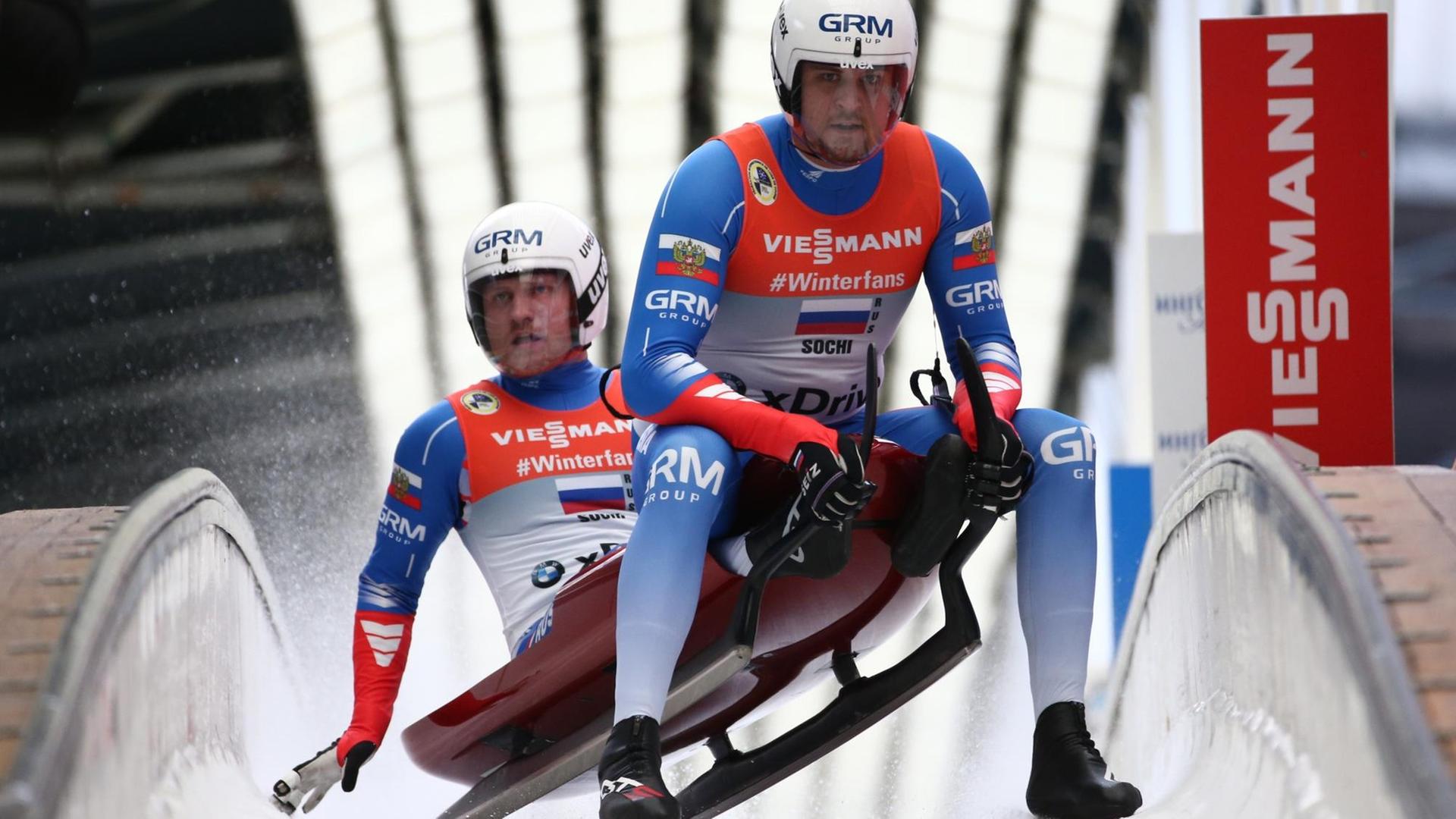 Die russischen Rodler Vladislav Antonov und Aleksandr Denisev bremsen im Auslauf der Bahn von Sotschi. Die russischen Rodler Vladislav Antonov und Aleksandr Denisev bremsen im Auslauf der Bahn von Sotschi.