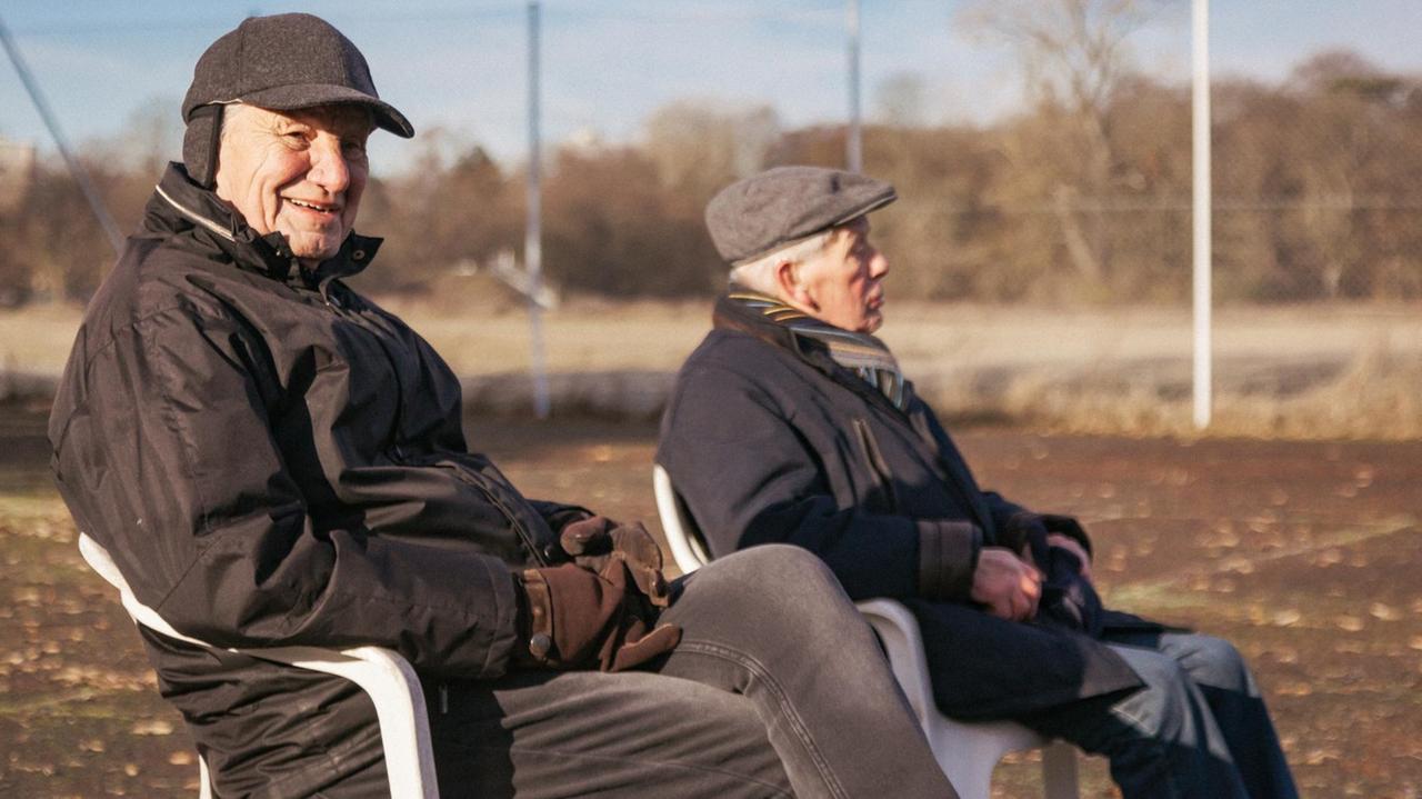 Zwei ältere Herren sitzen am Spielfeldrand Zwei ältere Herren sitzen am Spielfeldrand