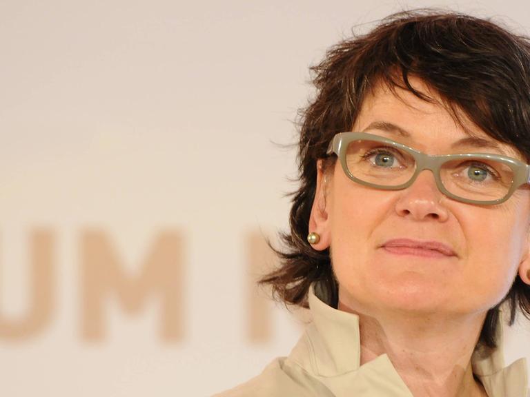 Frauke Gerlach, die Direktorin des Grimme-Instituts, in beiger Kleidung mit beiger Brille vor beigem Hintergrund.