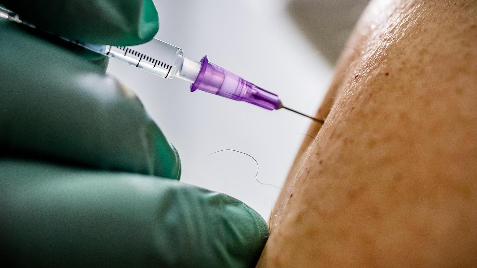 Ein Arzt verimpft die zweite Dosis Biontech-Pfizer-Impfstoff im Corona Impfzentrum Messe Berlin. Im Impfzentrum der Malteser wird der Impfstoff von Biontech-Pfizer an täglich über 3000 Berlinerinnen und Berliner verimpft.