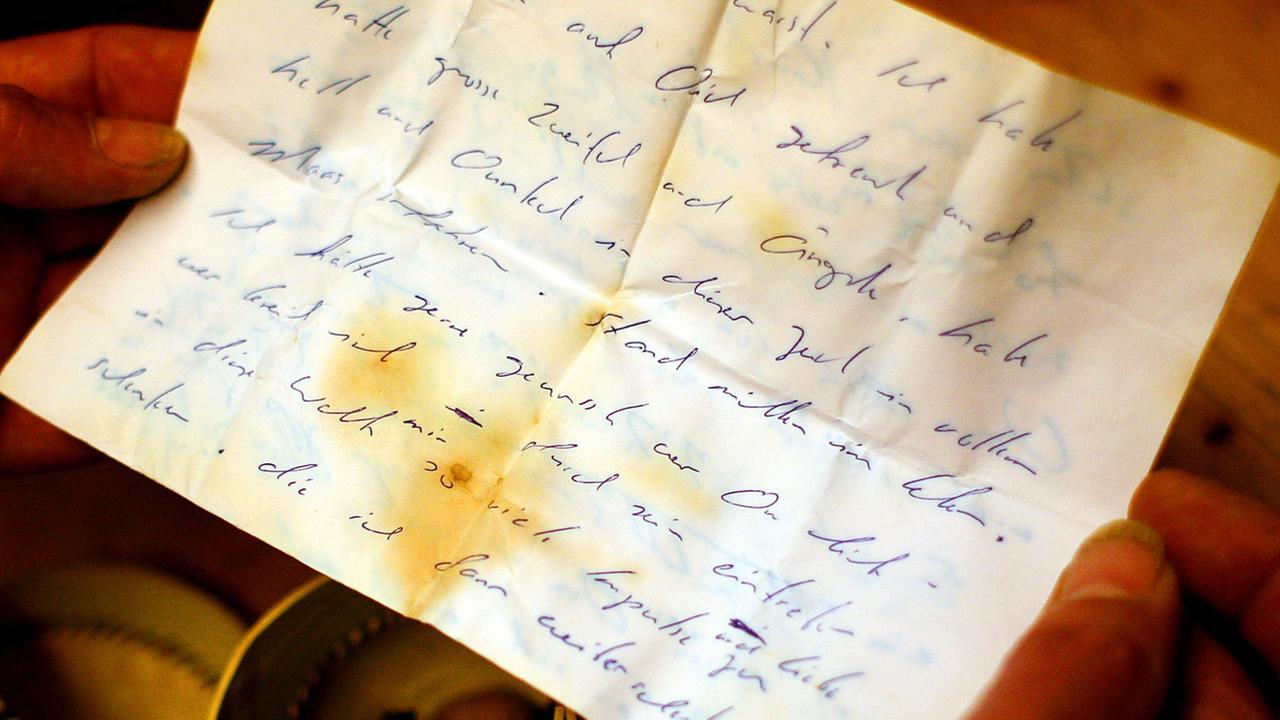 Der Künstler Joachim Römer liest in einem Brief aus einer Flaschenpost. Der Künstler Joachim Römer liest in einem Brief aus einer Flaschenpost.