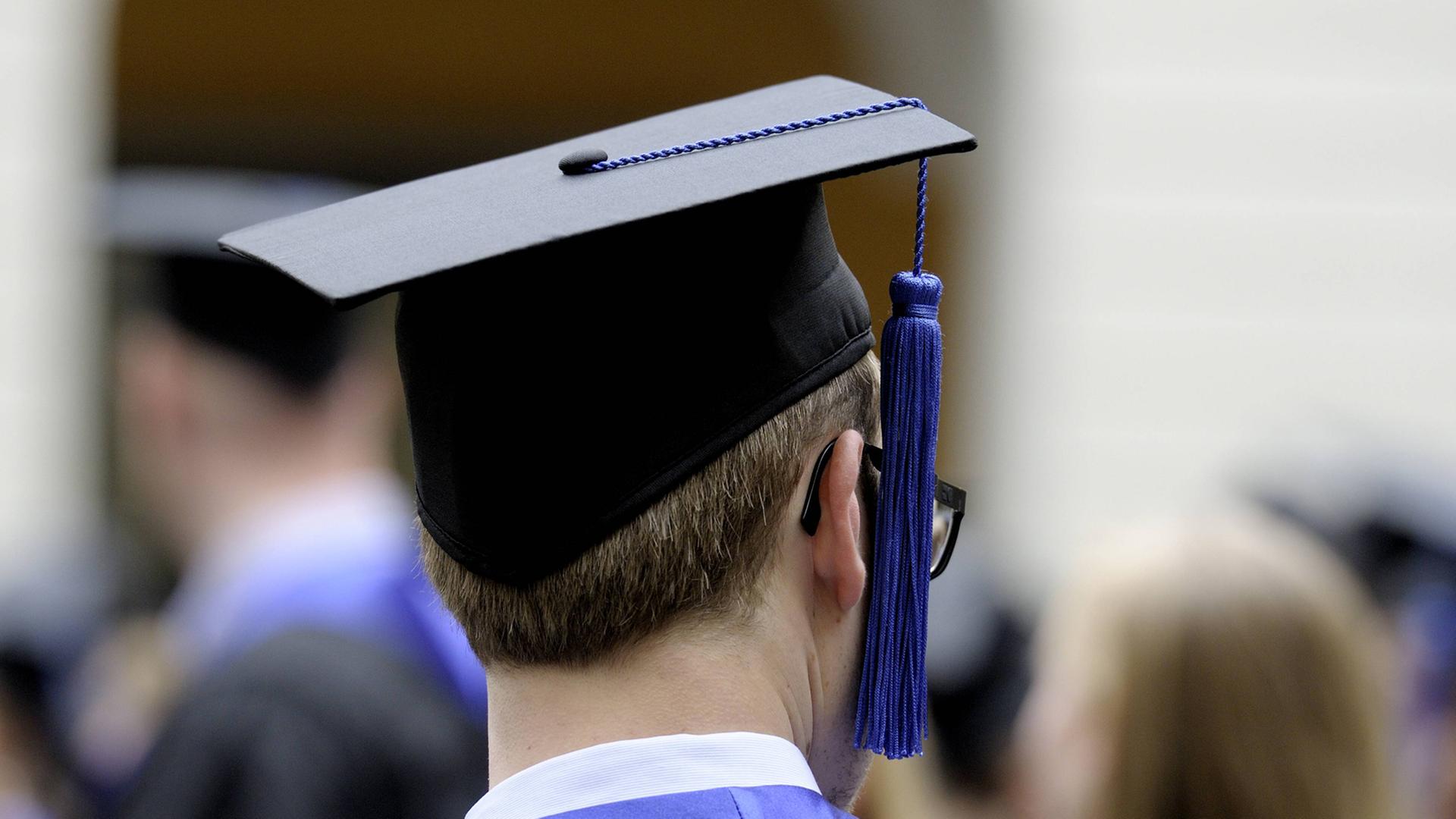 Ein Student der Universität Bonn in Talar und Barett / Doktorhut während der Abschlussfeier Ein Student der Universität Bonn in Talar und Barett / Doktorhut während der Abschlussfeier
