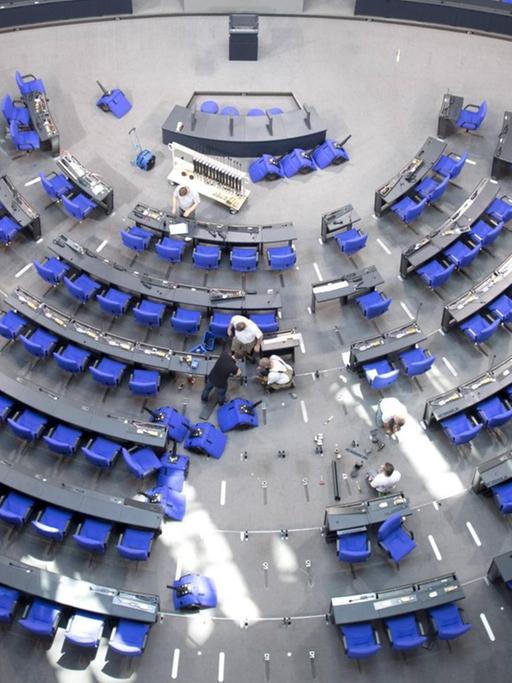 Arbeiter schrauben im Bundestag die Stühle für die Abgeordneten der anstehenden Legislaturperiode fest.
