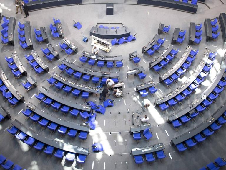 Arbeiter schrauben im Bundestag die Stühle für die Abgeordneten der anstehenden Legislaturperiode fest.