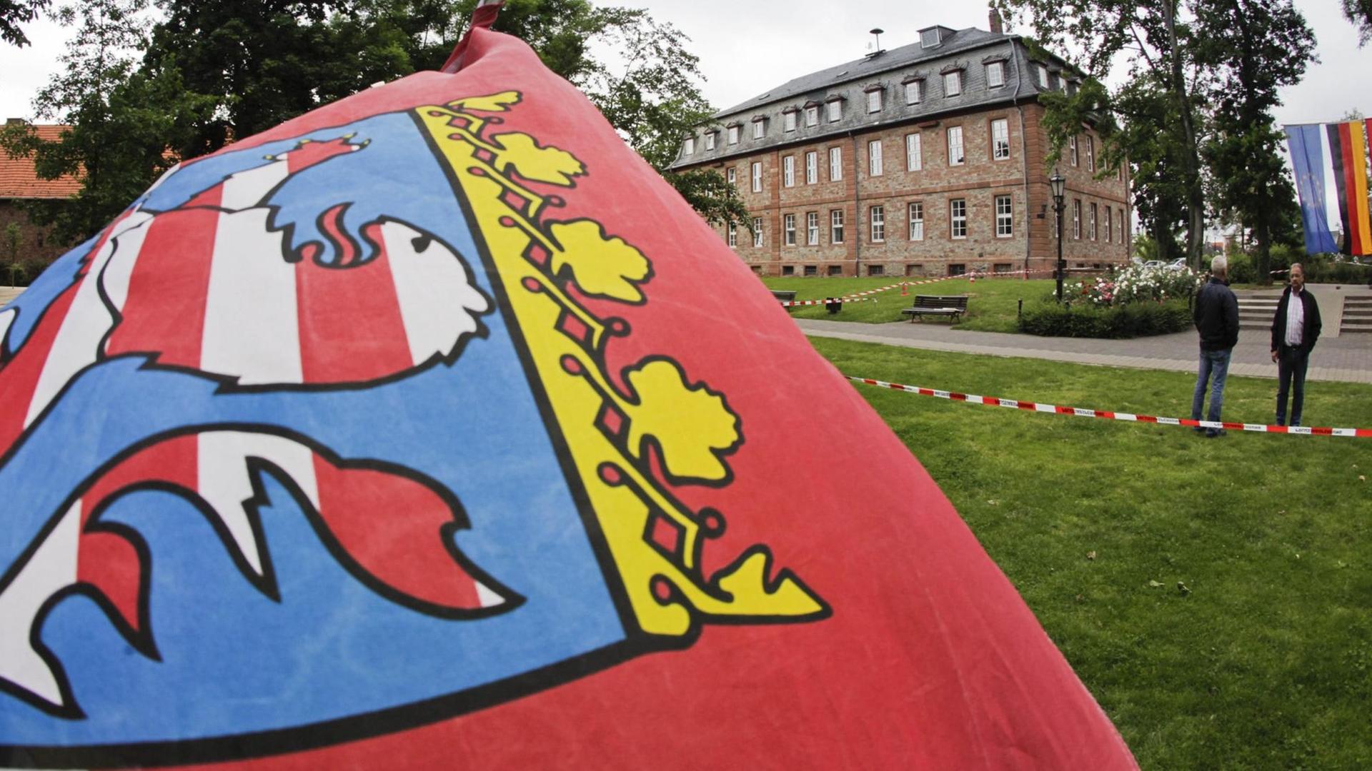 Eine hessische Landesfahne weht vor dem Schloss von Langenselbold, das heute als Rathaus dient.