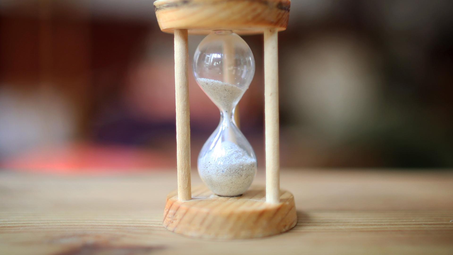 Eine Sanduhr. Das obere Glas ist noch halb voll. Eine Sanduhr. Das obere Glas ist noch halb voll.