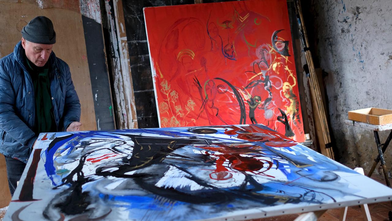 Der Künstler Valère Novarina betrachtet in seinem Atelier eins seiner Werke. Ein weiteres Werk steht im Hintergrund. Der Künstler Valère Novarina betrachtet in seinem Atelier eins seiner Werke. Ein weiteres Werk steht im Hintergrund.