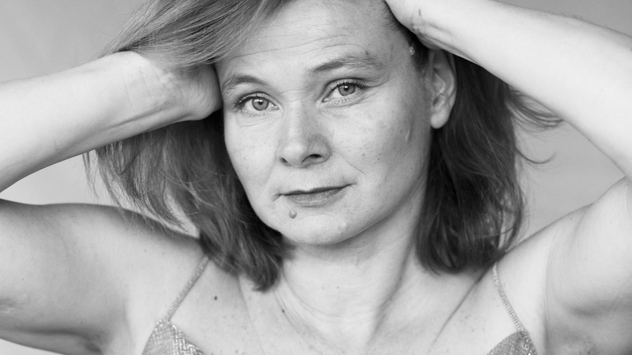 Die Sängerin trägt ein Trägerhemd, schiebt ihre Hände in die Haare und schaut in die Kamera. Die Sängerin trägt ein Trägerhemd, schiebt ihre Hände in die Haare und schaut in die Kamera.