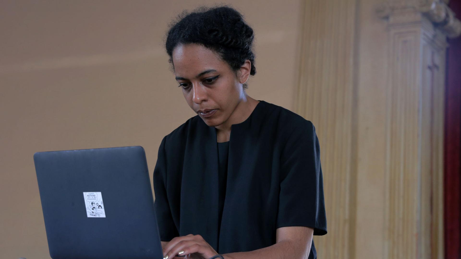 Die Klangkünstlerin Jessica Ekomane steht vor einem Laptop Die Klangkünstlerin Jessica Ekomane steht vor einem Laptop