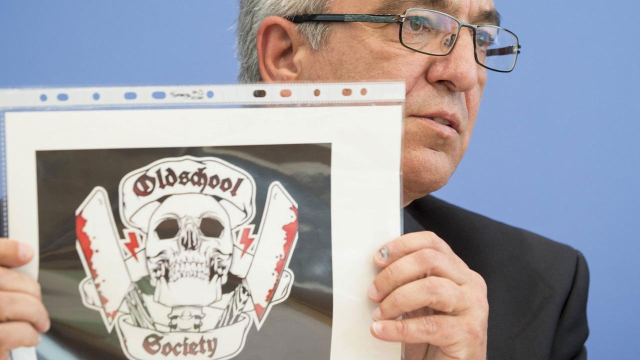Der Vorsitzende der Innenministerkonferenz, Roger Lewentz, zeigt das Logo der rechtsextremen Gruppierung "Oldschool Society" Der Vorsitzende der Innenministerkonferenz, Roger Lewentz, zeigt das Logo der rechtsextremen Gruppierung "Oldschool Society"