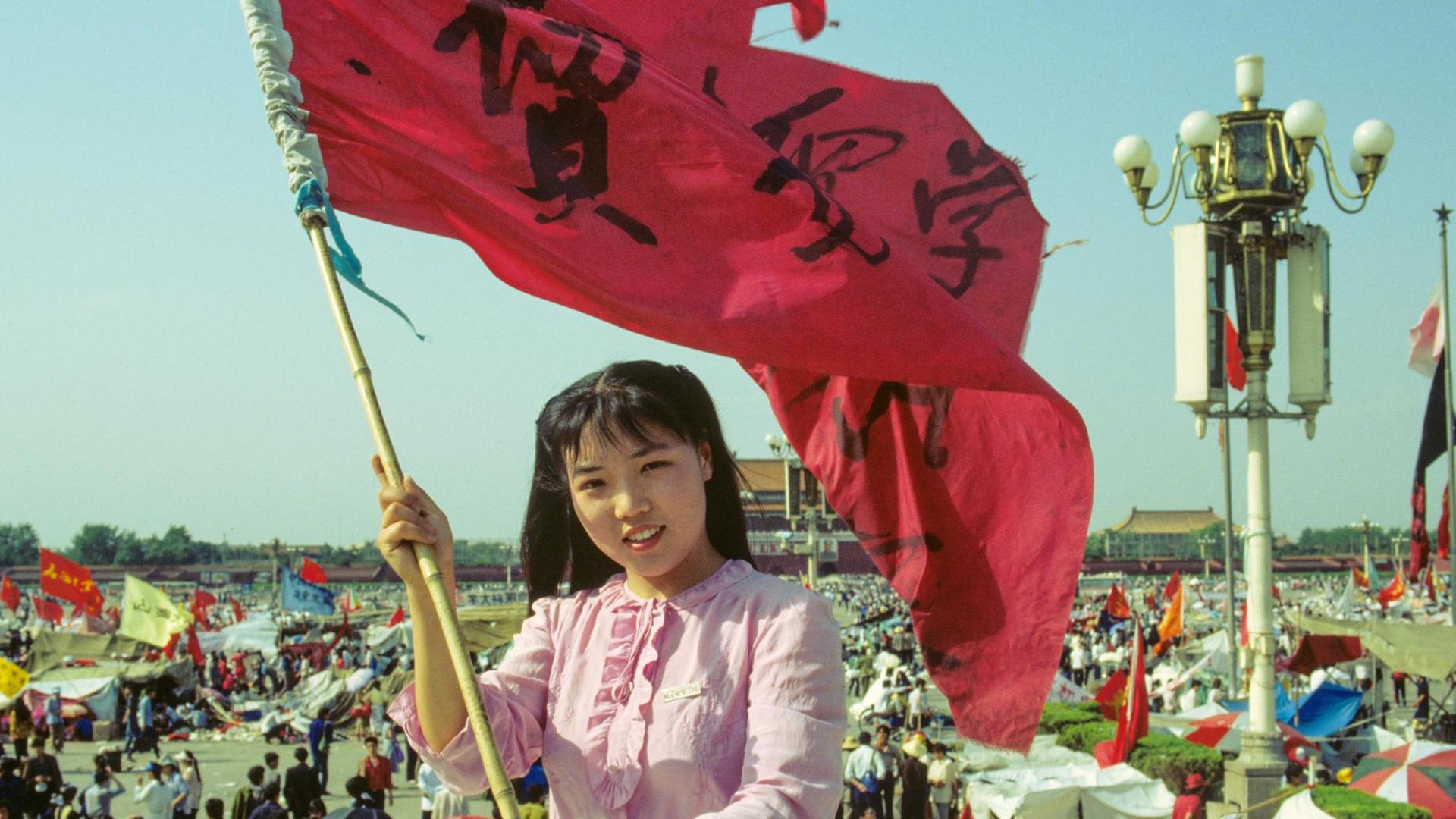Eine Studentin demonstriert in Peking am 27.5.1989 mit einem großen Banner