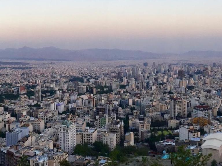 Sie sehen die Millionenstadt Teheran, es dämmert.