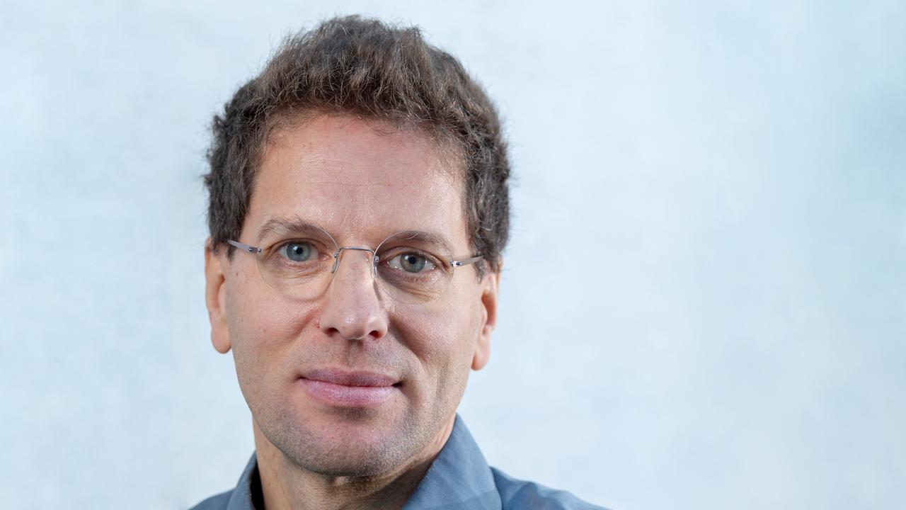 Porträt von Alexander Bogner, vor einem hellblauen Hintergrund. Porträt von Alexander Bogner, vor einem hellblauen Hintergrund.