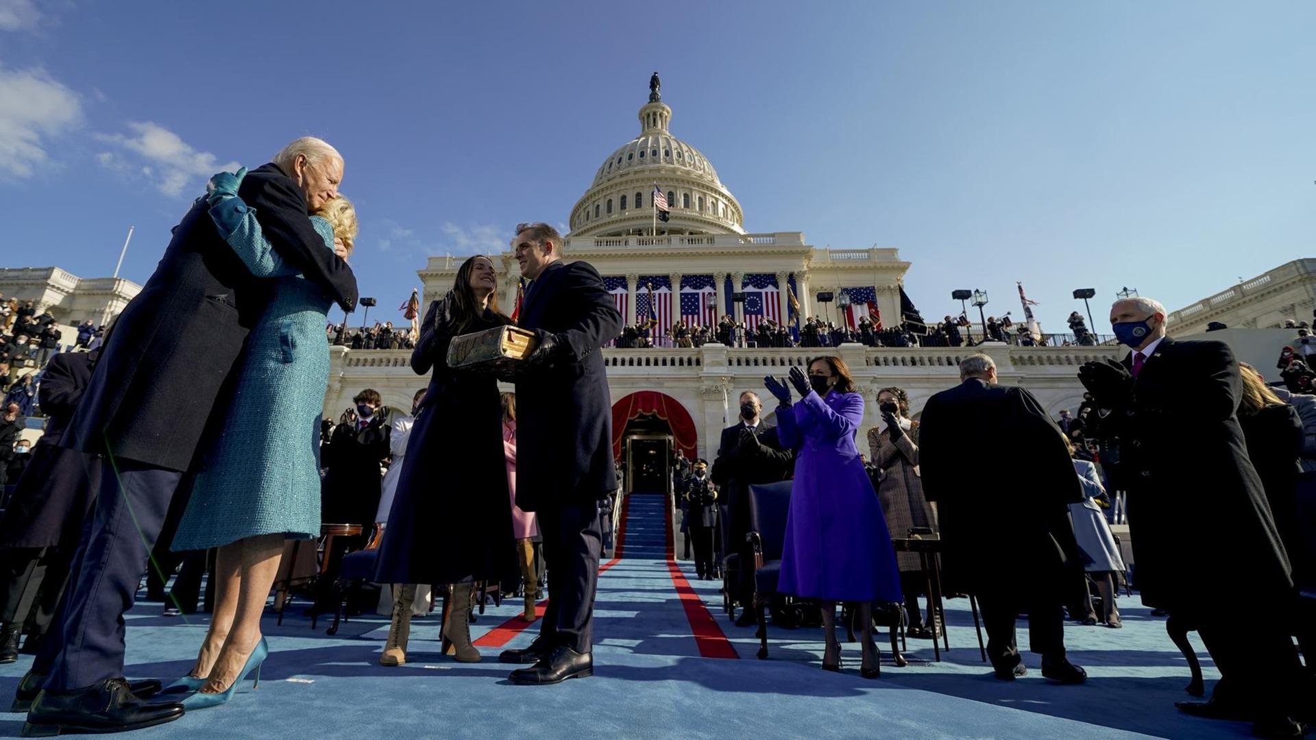 Ex-Vizepräsident Mike Pence applaudiert, als der frisch ins Amt eingeschworene Präsident Joe Biden seine Frau Jill umarmt. Ex-Vizepräsident Mike Pence applaudiert, als der frisch ins Amt eingeschworene Präsident Joe Biden seine Frau Jill umarmt.