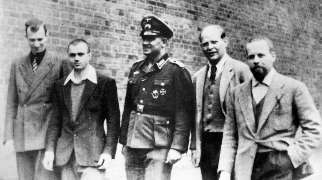 Das Schwarz-Weiß-Foto von 1944 zeigt Dietrich Bonhoeffer im Wehrmachtsgefängnis Berlin-Tegel. Er steht in einer Reihe mit gefangenen Offizieren der italienischen Luftwaffe und einem Wehrmachtsoffizier. V.l.n.r. Mario Gilli, Dante Curcio, Oberfeldwebel Napp, Bonhoeffer, Edmondo Tognelli. Das Schwarz-Weiß-Foto von 1944 zeigt Dietrich Bonhoeffer im Wehrmachtsgefängnis Berlin-Tegel. Er steht in einer Reihe mit gefangenen Offizieren der italienischen Luftwaffe und einem Wehrmachtsoffizier. V.l.n.r. Mario Gilli, Dante Curcio, Oberfeldwebel Napp, Bonhoeffer, Edmondo Tognelli.