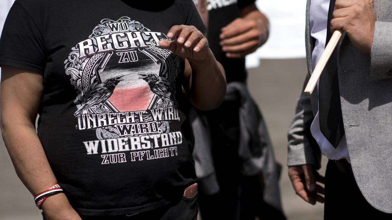 Bei einer Coronademo in Berlin trägt ein Teilnehmer, der Angehöriger einer rechtsextremen Bewegung ist, ein T-Shirt mit dem Slogan: Wo Recht zu Unrecht wird, wird Widerstand zur Pflicht.