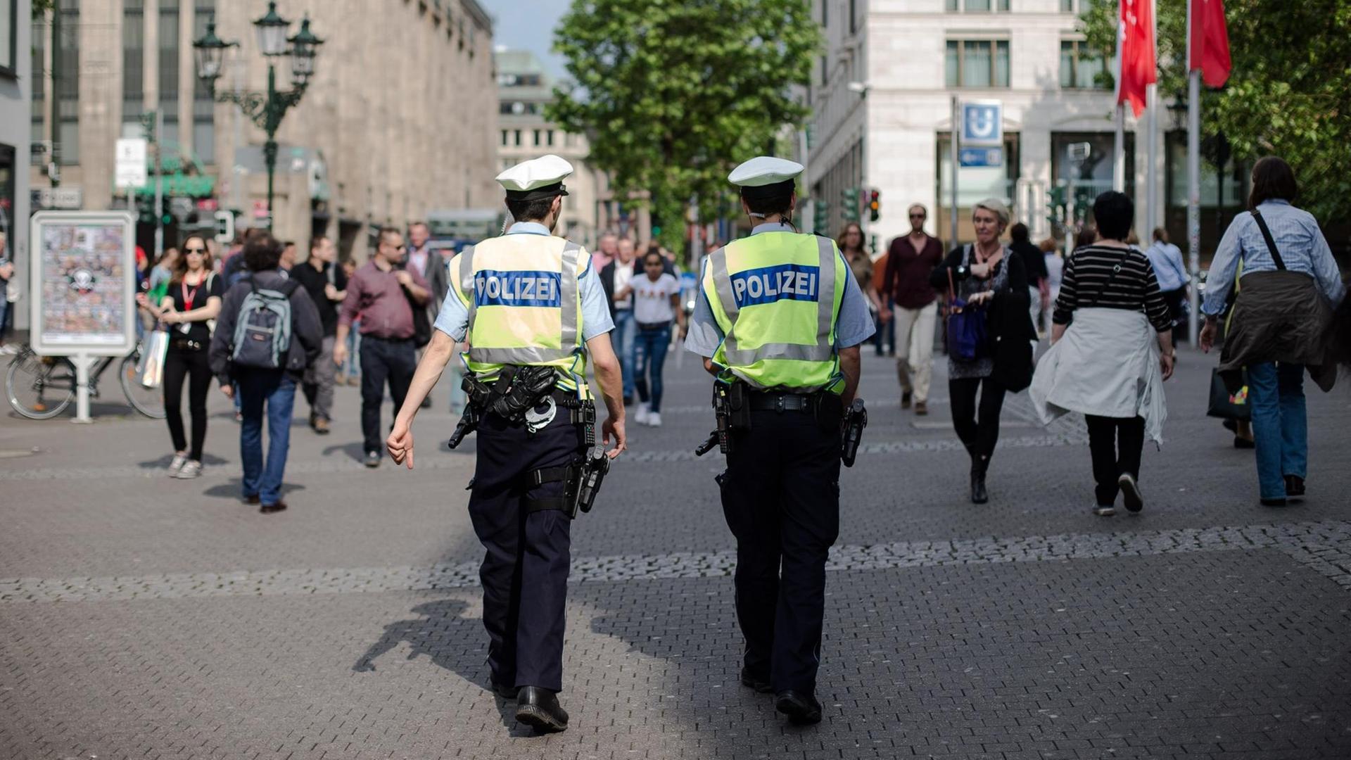 Polizisten gehen in der Altstadt in Düsseldorf streife.