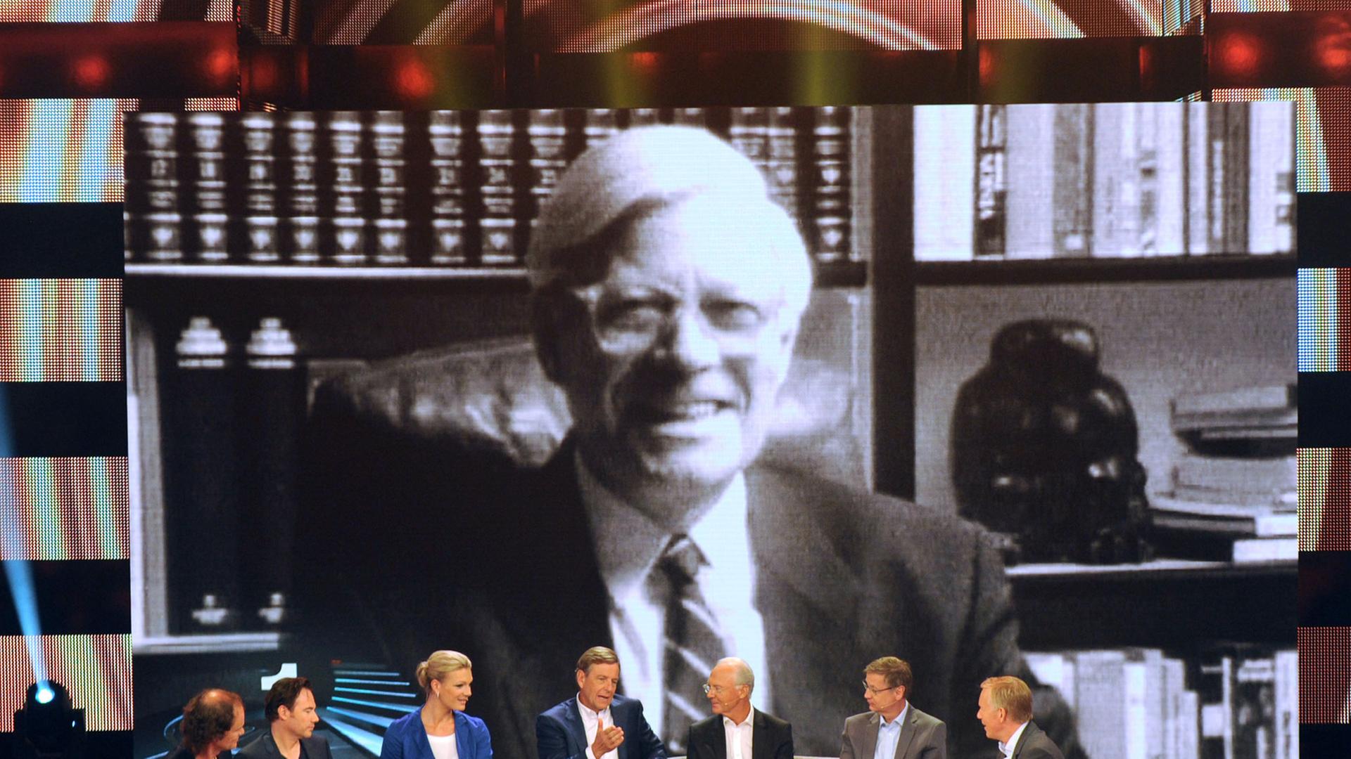 Moderator Johannes B. Kerner (r) sitzt in Köln (Nordrhein-Westfalen) in der ZDF-Show "Deutschlands Beste - Männer" neben seinen Gästen: Comedian Olaf Schubert (l-r), Comedian Michael «Bully» Herbig, Sportlerin Maria Höfl-Riesch, Journalist Claus Kleber, Sportler Franz Beckenbauer und Moderator Günther Jauch. Im Hintergrund ein Bild von Politiker Helmut Schmidt, der auf Platz Eins gewählt wurde. Moderator Johannes B. Kerner (r) sitzt in Köln (Nordrhein-Westfalen) in der ZDF-Show "Deutschlands Beste - Männer" neben seinen Gästen: Comedian Olaf Schubert (l-r), Comedian Michael «Bully» Herbig, Sportlerin Maria Höfl-Riesch, Journalist Claus Kleber, Sportler Franz Beckenbauer und Moderator Günther Jauch. Im Hintergrund ein Bild von Politiker Helmut Schmidt, der auf Platz Eins gewählt wurde.