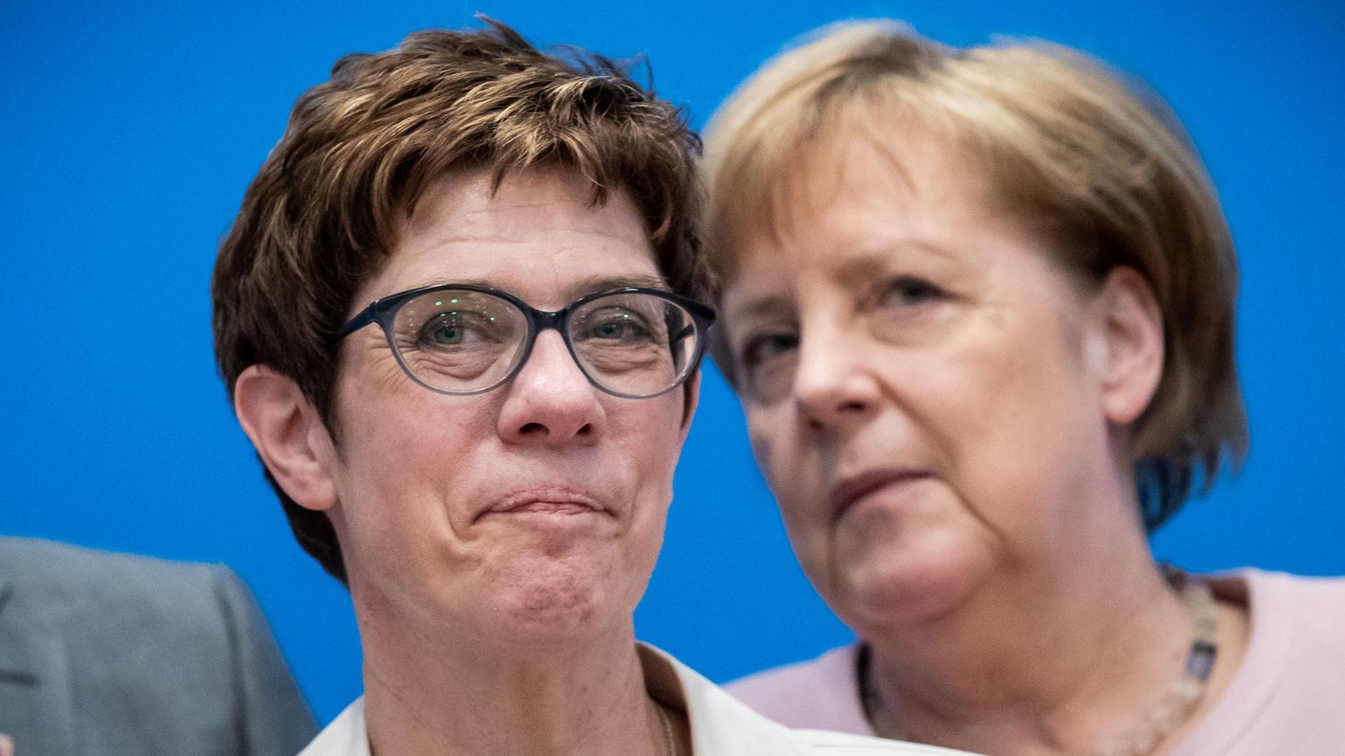 Annegret Kramp-Karrenbauer (l), Bundesvorsitzende der CDU, wartet neben Bundeskanzlerin Angela Merkel (CDU), auf den Beginn der Klausurtagung des CDU-Bundesvorstands