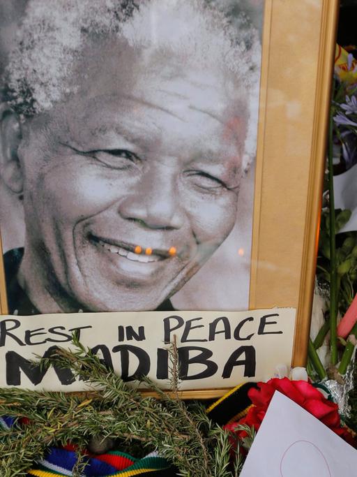 Ein Porträt Nelson Mandels geschmückt mit Blumen nach der Bakanntgabe seines Todes