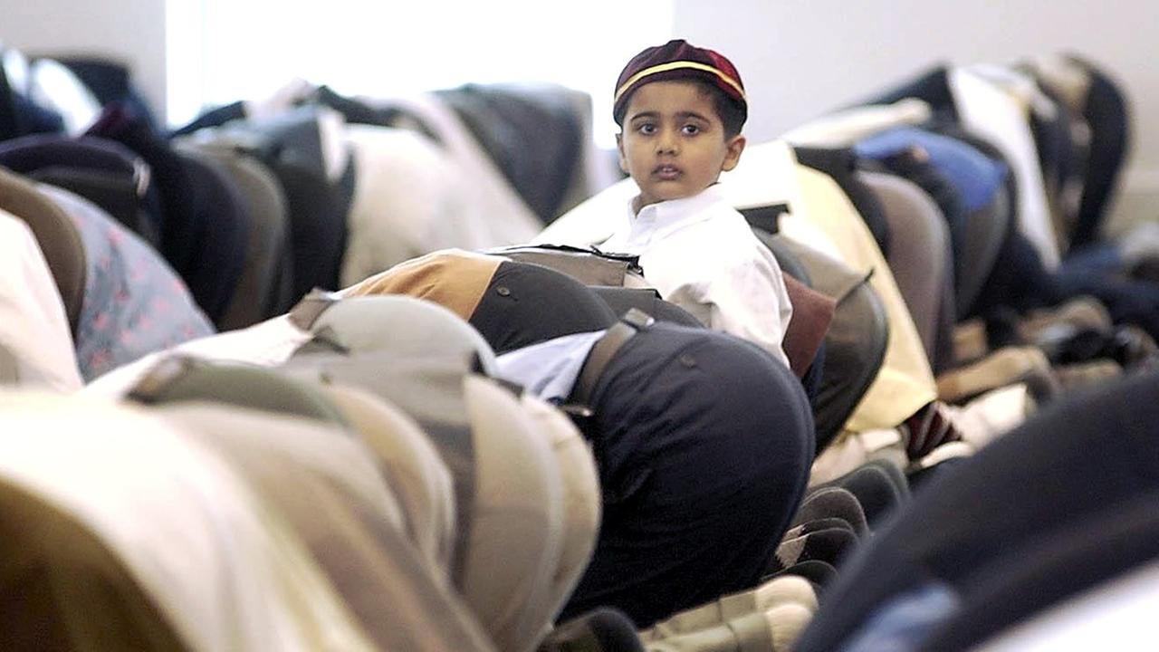 Betende Männer und ein kleiner Junge in der Baitul Futuh Moschee in Morden, London Betende Männer und ein kleiner Junge in der Baitul Futuh Moschee in Morden, London