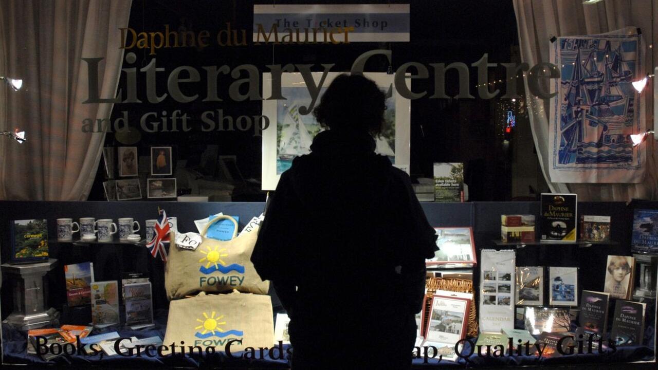 Eine Frau schaut in das Schaufenster eines Buchladens in Großbritannien. Eine Frau schaut in das Schaufenster eines Buchladens in Großbritannien.