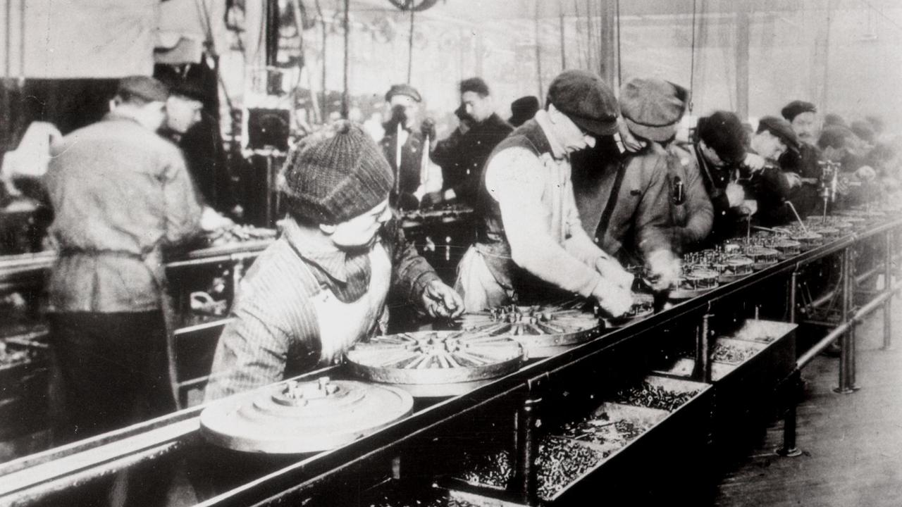 Arbeiter an einem Fließband bei der Montage des Model T von Ford in den USA.