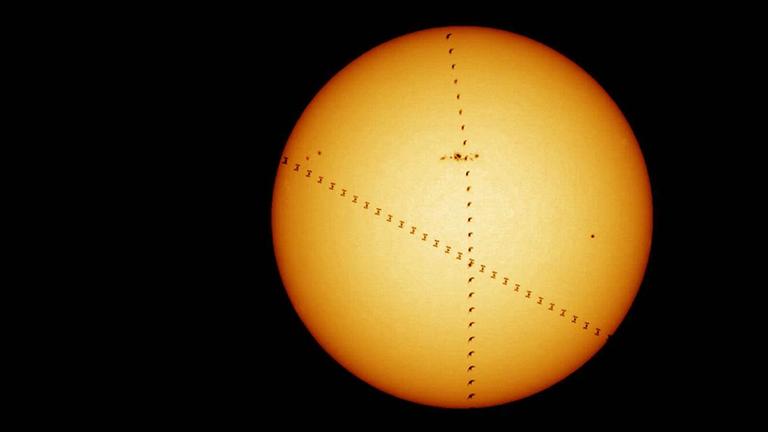 Die ISS zieht von rechts unten nach links oben über die Sonne, der Vogel von unten senkrecht nach oben Die ISS zieht von rechts unten nach links oben über die Sonne, der Vogel von unten senkrecht nach oben