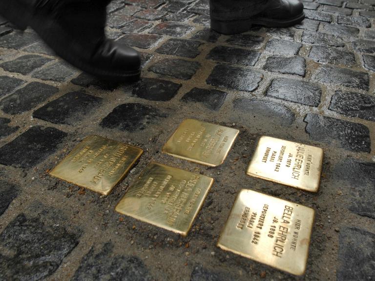 Ein Passant läuft in der Regensburger Innenstadt an "Stolpersteinen" vorbei.
