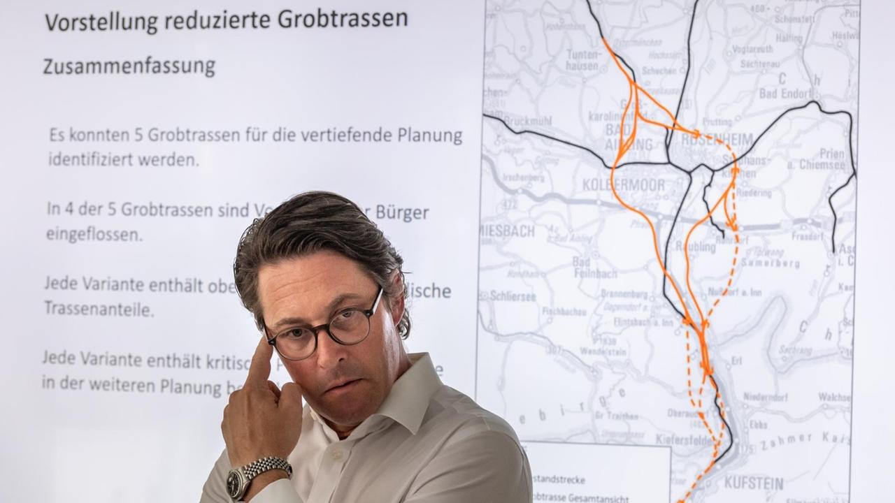 Bundesverkehrsminister Andreas Scheuer nimmt an einer Pressekonferenz der Deutschen Bahn zu den Vorschlägen für die fünf möglichen Trassenverläufe des sogenannten Brenner-Nordzulauf teil. Im Hintergrund ist eine Karte mit den fünf möglichen Streckenverläufen rund um Rosenheim. Bundesverkehrsminister Andreas Scheuer nimmt an einer Pressekonferenz der Deutschen Bahn zu den Vorschlägen für die fünf möglichen Trassenverläufe des sogenannten Brenner-Nordzulauf teil. Im Hintergrund ist eine Karte mit den fünf möglichen Streckenverläufen rund um Rosenheim.