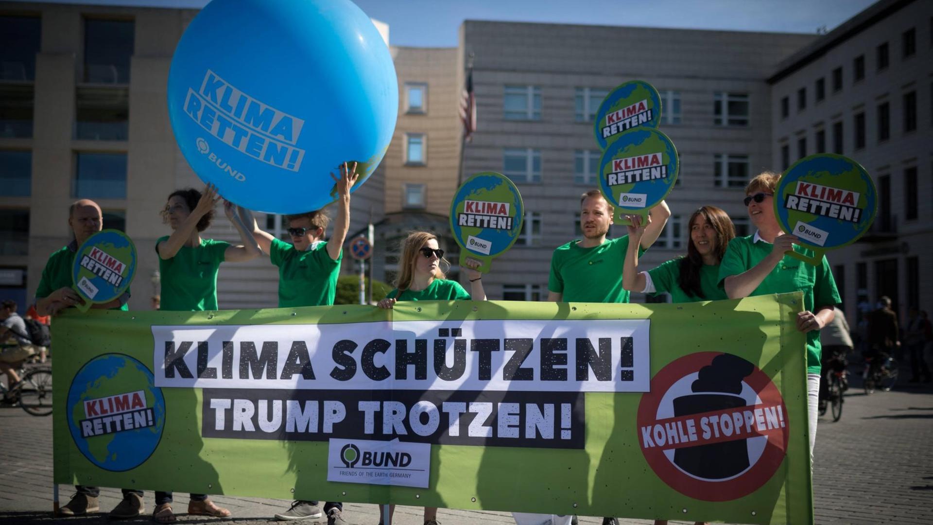 Aktivisten der Umweltorganisation demonstrieren gegen die Klimapoltik der USA mit Transparenten Aktivisten der Umweltorganisation demonstrieren gegen die Klimapoltik der USA mit Transparenten